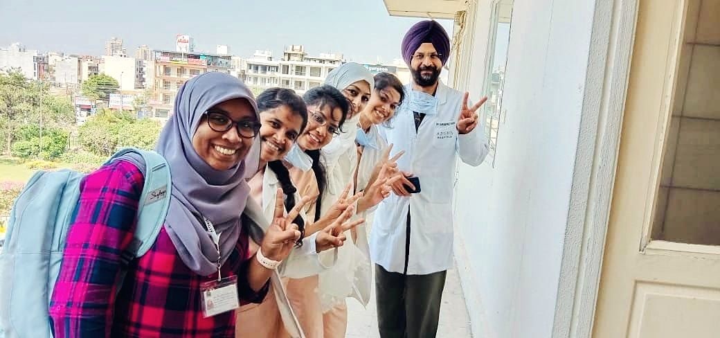 Dr. Sarabpreet Singh with a group of smiling trainees on a hospital balcony