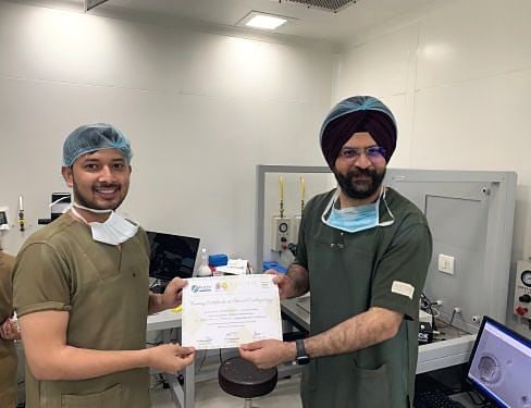 A trainee receives a course certificate from Dr. Sarabpreet Singh in the lab