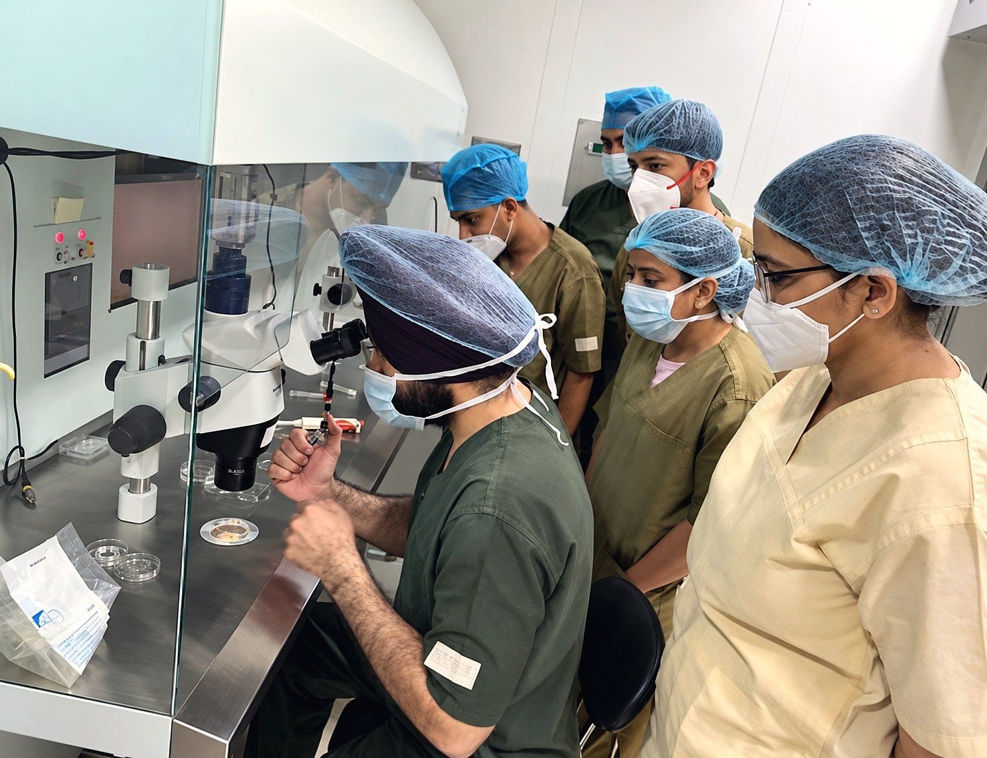 Trainees watch an ICSI demonstration at a micromanipulator station
